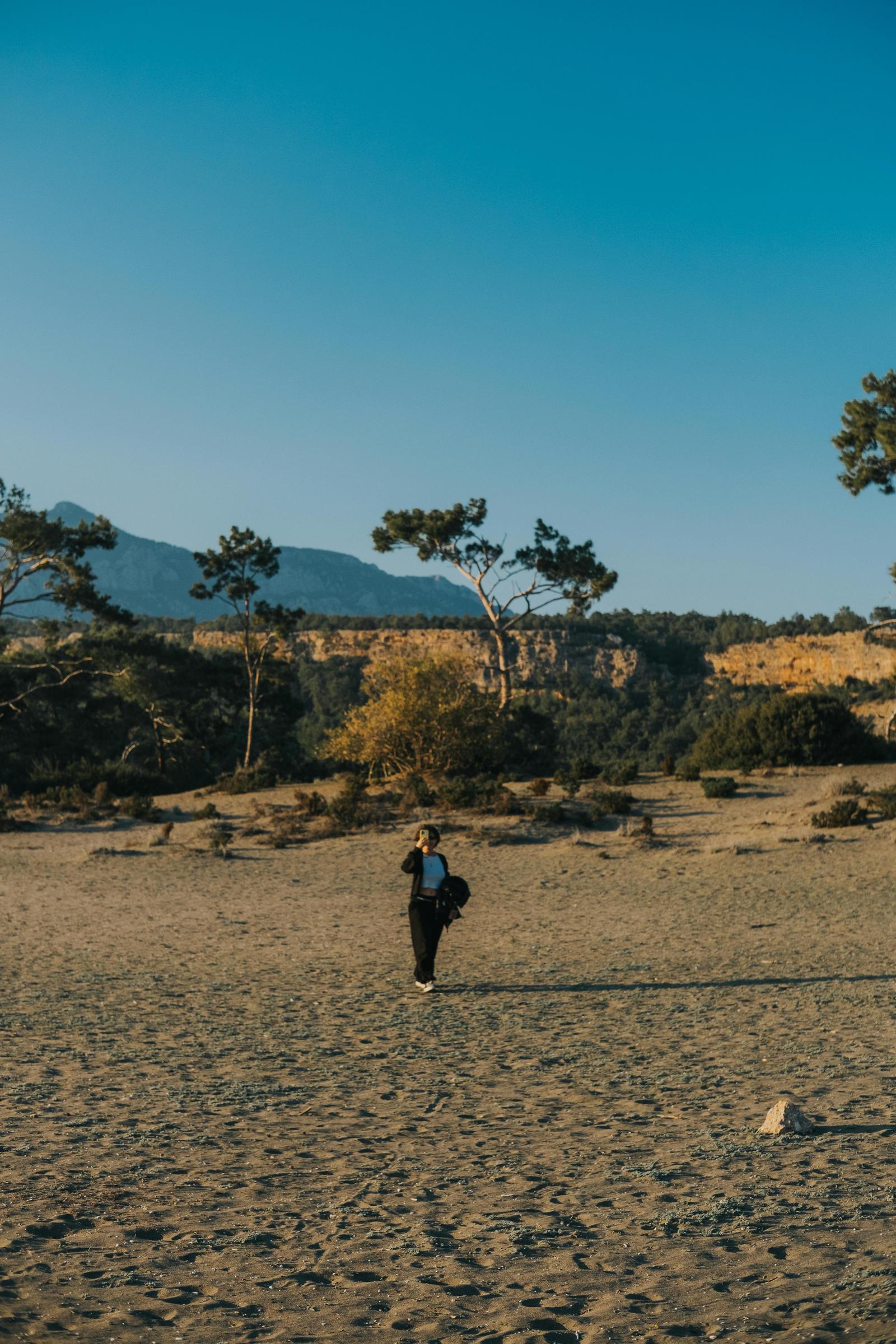 Traveler framed by a wide sandy landscape